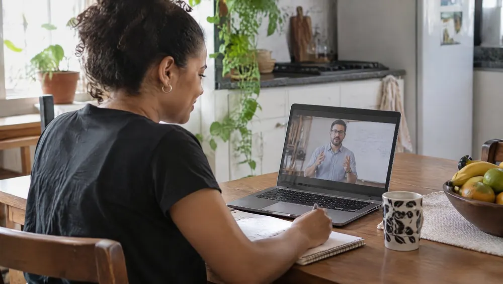 Aluna assistindo a uma aula on-line no notebook